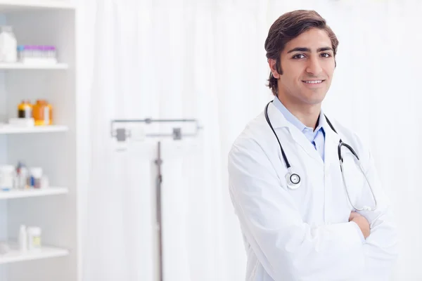 Smiling doctor standing in examination room — Stock Photo, Image