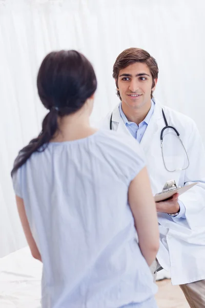 Jonge arts praten met patiënt — Stockfoto