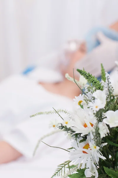 Flowers next to woman about to get surgery — Stock Photo, Image
