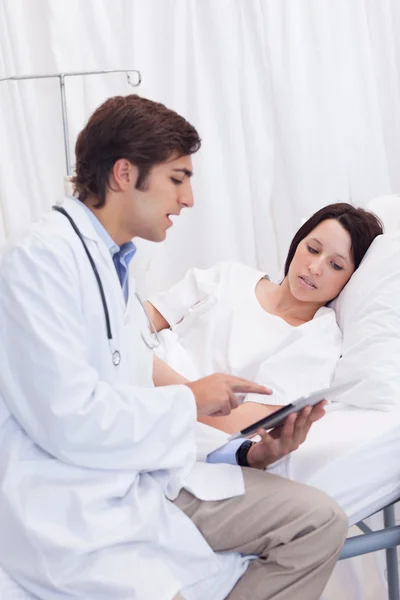 Доктор показывает пациенту, что у него на планшете — стоковое фото