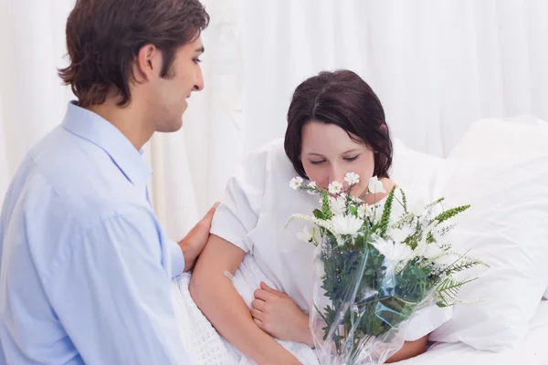 男は病院の彼のガール フレンドに花をもたらした — ストック写真