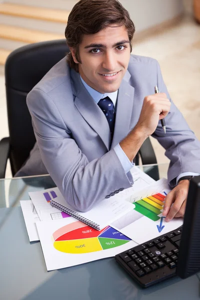 Un hombre de negocios sonriente trabajando en estadísticas —  Fotos de Stock
