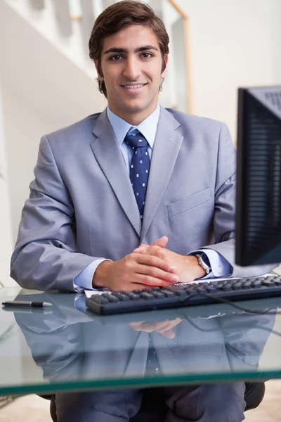 Улыбающийся бизнесмен сидит за компьютером — стоковое фото