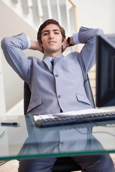 Empresário inclinado para trás em seu escritório — Fotografia de Stock