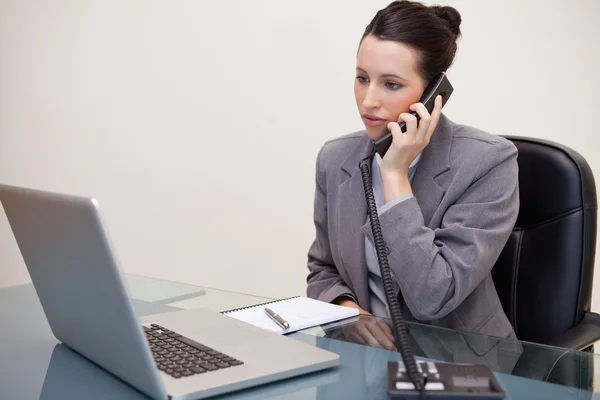 Donna d'affari seduta alla scrivania al telefono — Foto Stock