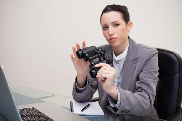 Affärskvinna på hennes skrivbord med kikare — Stockfoto