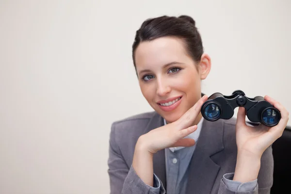 Улыбающаяся деловая женщина с биноклем — стоковое фото