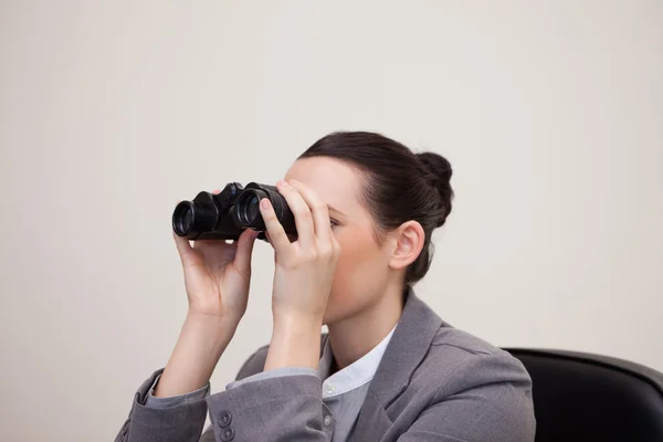 Empresaria echando un vistazo a través de los prismáticos — Foto de Stock