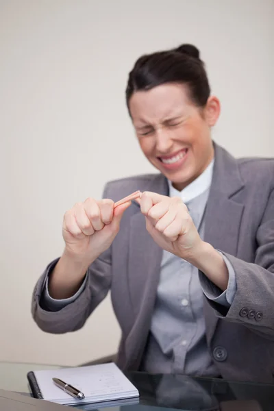 Angry businesswoman breaking pencil — Stock Photo, Image