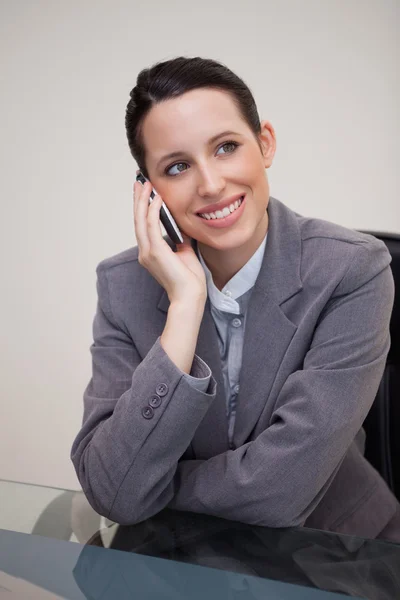 Businesswoman on the cellphone behind her desk — Stock Photo, Image
