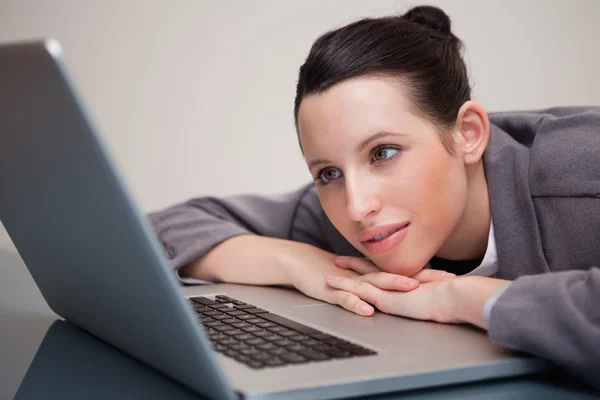 Zakenvrouw leunend tegen haar laptop — Stockfoto