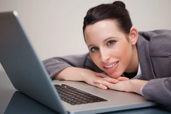 Glad affärskvinna lutad mot sin laptop — Stockfoto