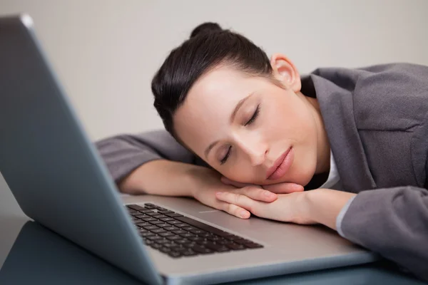 Empresária tirando uma soneca em seu laptop — Fotografia de Stock