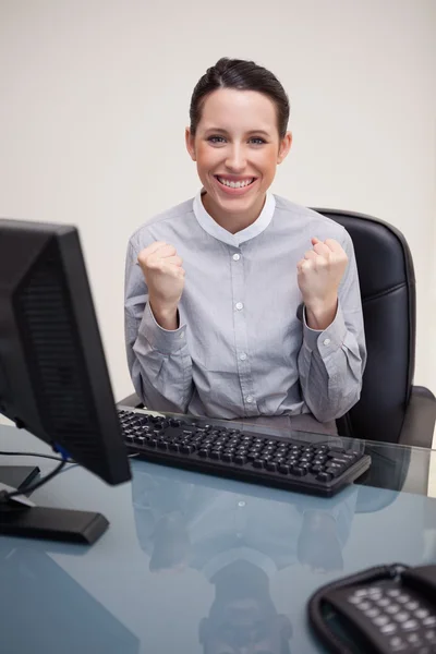 Affärskvinna bakom sitt skrivbord med en framgång — Stockfoto