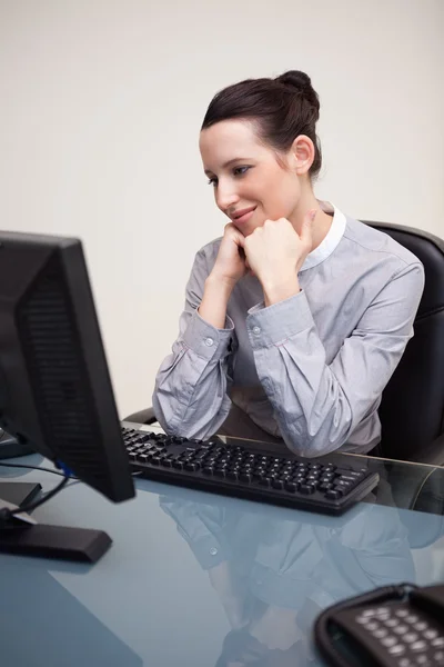 Ευτυχής χαμογελαστοί επιχειρηματίας που κάθεται στο γραφείο της — Φωτογραφία Αρχείου