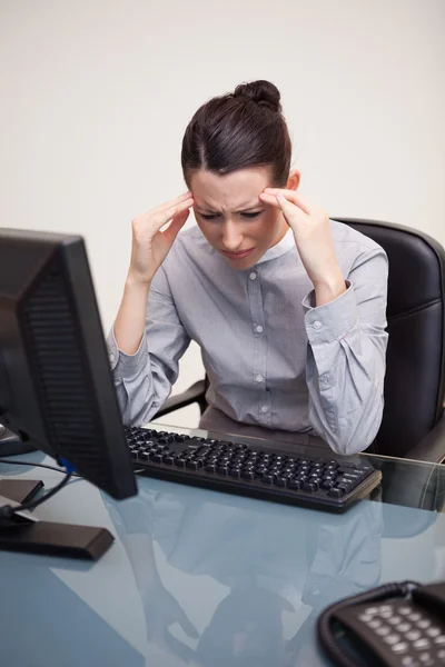 Empresaria con dolor de cabeza en su escritorio — Foto de Stock