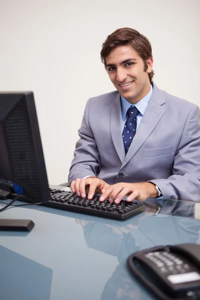 Χαμογελώντας επιχειρηματίας δακτυλογράφηση στο πληκτρολόγιο του — Φωτογραφία Αρχείου