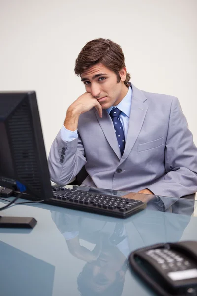 Geschäftsmann sitzt gelangweilt an seinem Arbeitsplatz — Stockfoto