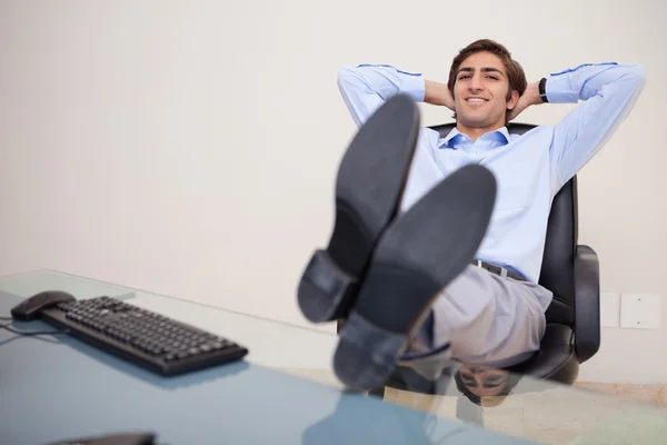 Lachende zakenman leunend terug in zijn stoel — Stockfoto