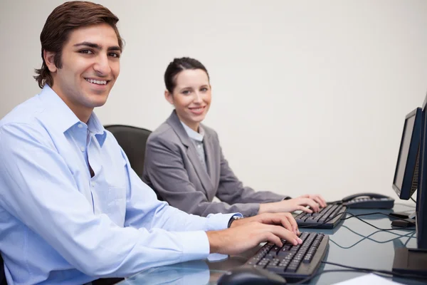 Side view of smiling colleagues working next to each other — Stock Photo, Image
