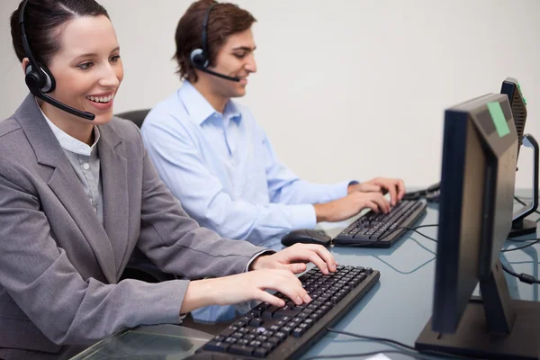 Zijaanzicht van call center agenten werken naast elkaar — Stockfoto