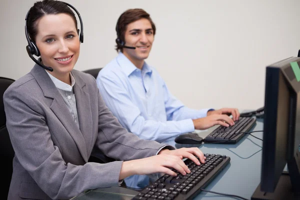 Vista lateral dos agentes sorridentes do call center no trabalho — Fotografia de Stock