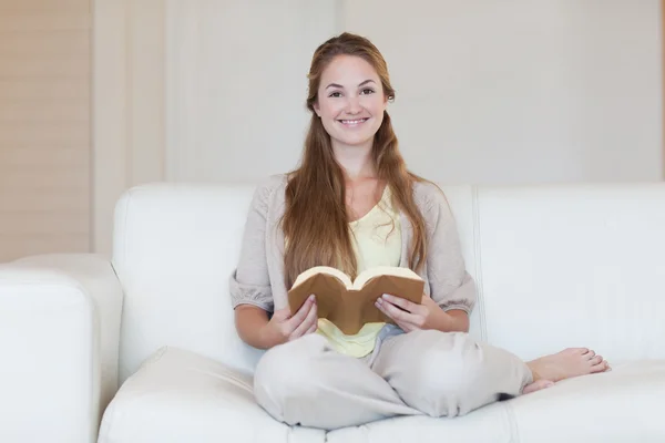 Frau liest Buch auf der Couch — Stockfoto