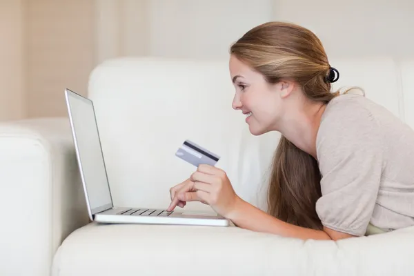 Вид женщины на диване, делающей покупки онлайн — стоковое фото