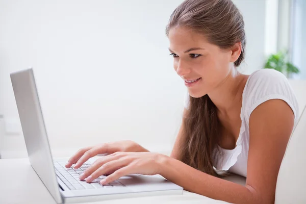 Zijaanzicht van lachende vrouw op haar laptop — Stockfoto