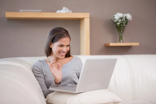 Vrolijke vrouw met haar laptop op de Bank — Stockfoto