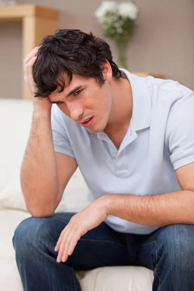Despaired man sitting on the sofa — Stock Photo, Image