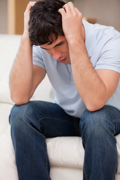 Frustrated man sitting on the couch — Stock Photo, Image