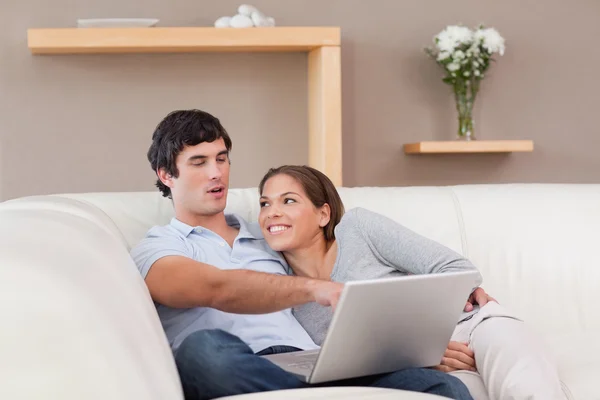 Couple avec leur ordinateur portable sur le canapé — Photo