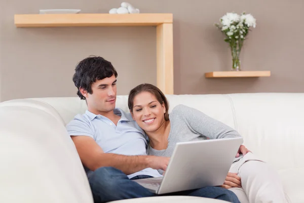 Casal com seu laptop no sofá — Fotografia de Stock