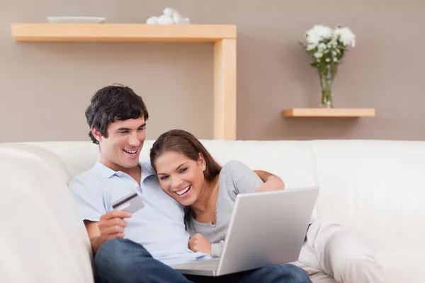 Couple sur le canapé shopping en ligne — Photo