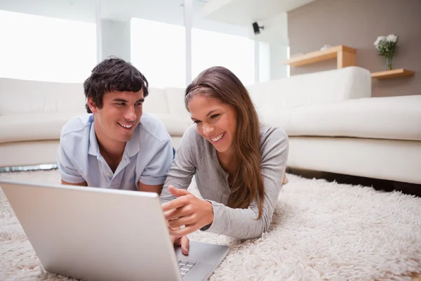 Par med laptop på mattan — Stockfoto