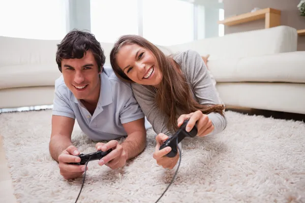 Casal jogando videogames no chão — Fotografia de Stock