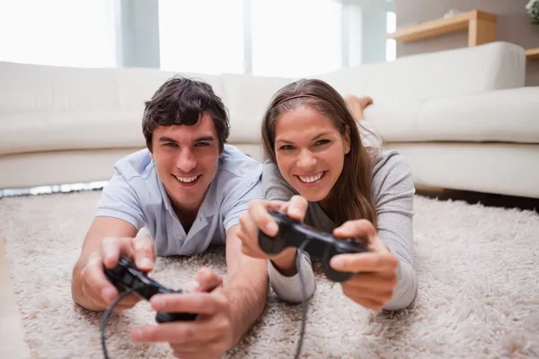 Casal jogando jogos de vídeo na sala de estar — Fotografia de Stock