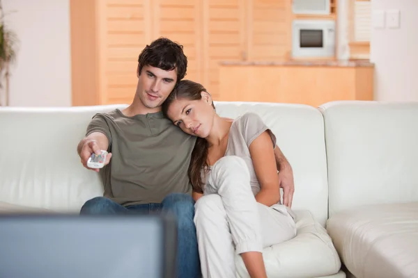 Casal no sofá assistindo televisão juntos — Fotografia de Stock