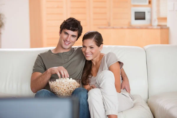 Pareja con palomitas de maíz en el sofá viendo una película —  Fotos de Stock