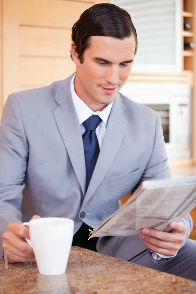 Biznesmen w kuchni, czytania wiadomości i filiżankę kawy — Zdjęcie stockowe