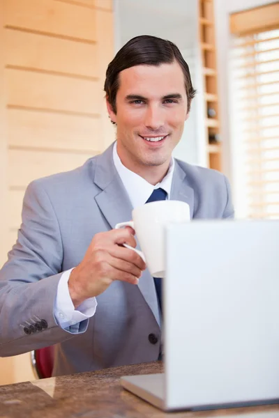 Χαμογελώντας επιχειρηματίας με φορητό υπολογιστή και καφέ — Φωτογραφία Αρχείου