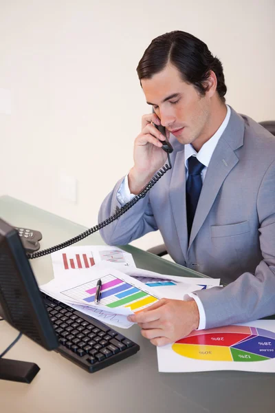 Businessman on the phone talking about statistics — Stock Photo, Image