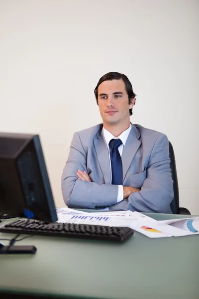 Uomo d'affari con le braccia incrociate in attesa del suo computer — Foto Stock