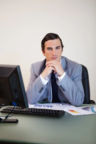 Geschäftsmann sitzt hinter seinem Schreibtisch — Stockfoto