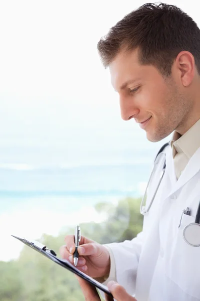 Side view of doctor taking notes — Stock Photo, Image
