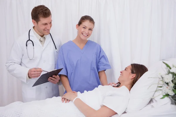 Médicos trayendo buenas noticias al paciente — Foto de Stock