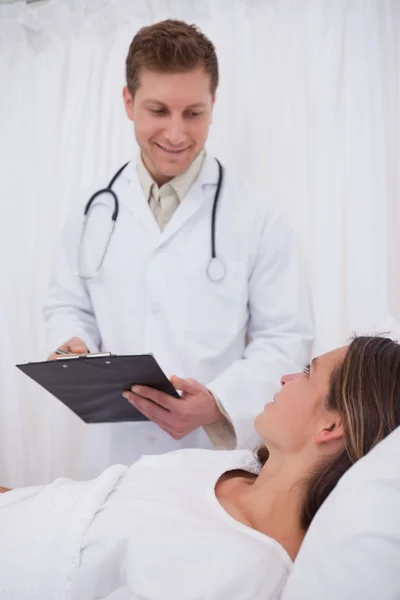 Läkare pratar med sängliggande patient — Stockfoto