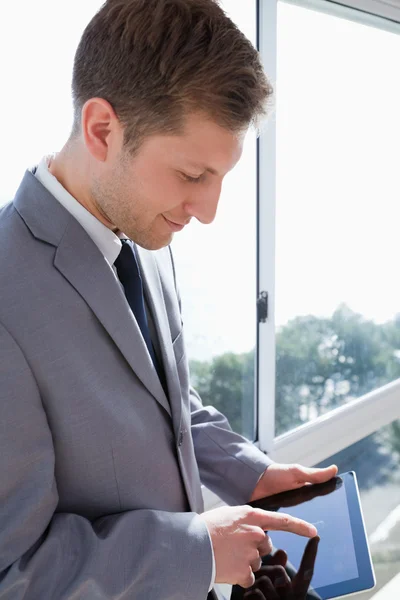Empresário com tablet na frente da janela — Fotografia de Stock