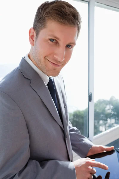Businessman with his tablet in front of the window — Stock Photo, Image